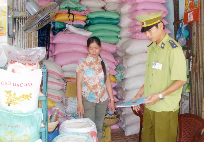 Nhân viên quản lý thị trường làm nhiệm vụ kiểm tra chất lượng hàng hoá tại chợ Quy Đạt.