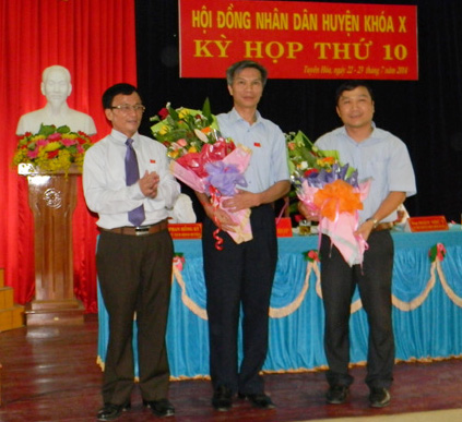 Đồng chí Trần Xuân Cầm, Phó Bí thư Thường trực Huyện ủy, Chủ tịch HĐND huyện tặng hoa các đồng chí thôi giữ các chức danh UBND huyện.