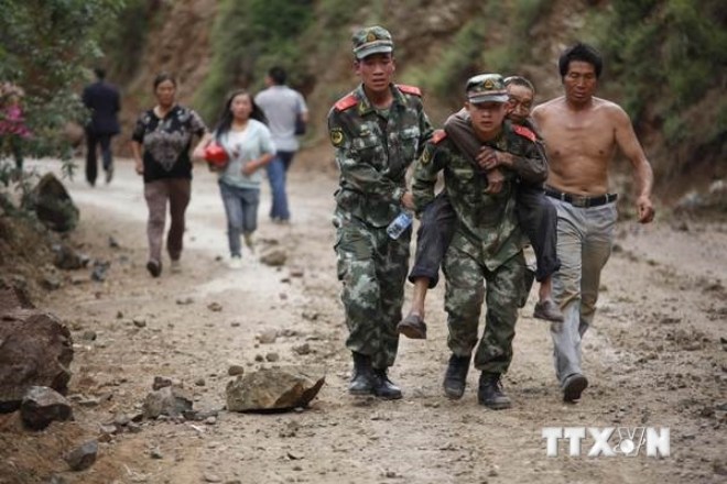 Lực lượng cứu hộ hỗ trợ người dân bị thương trong trận động đất tại huyện Lỗ Điện ngày 3-8. (Ảnh: THX/TTXVN)
