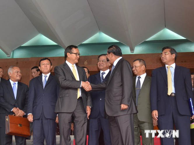 Thủ tướng Hun Sen và Chủ tịch CNRP Sam Rainsy bắt tay tuyên bố về thỏa thuận giải quyết bế tắc chính trị vừa đạt được. (Ảnh: Trần Chí Hùng/TTXVN)