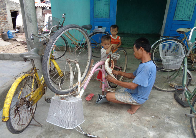Anh Nguyễn Văn Long (Tân Mỹ, Quảng Phúc) ngoài đi biển phải làm thêm nghề vá xe đạp.