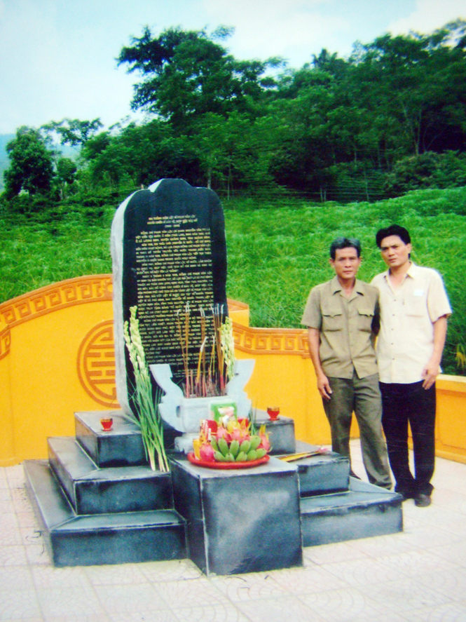 Anh Lê Văn Lợi (áo tối màu) bên cạnh bia tưởng niệm liệt sỹ Hoàng Văn Lộc tại Khu di tích lịch sử ATK Định Hóa, Thái Nguyên.