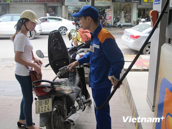 Nhân viên cửa hàng xăng dầu của Petrolimex đang bán xăng cho khách hàng (Ảnh: Đức Duy/Vietnam+)