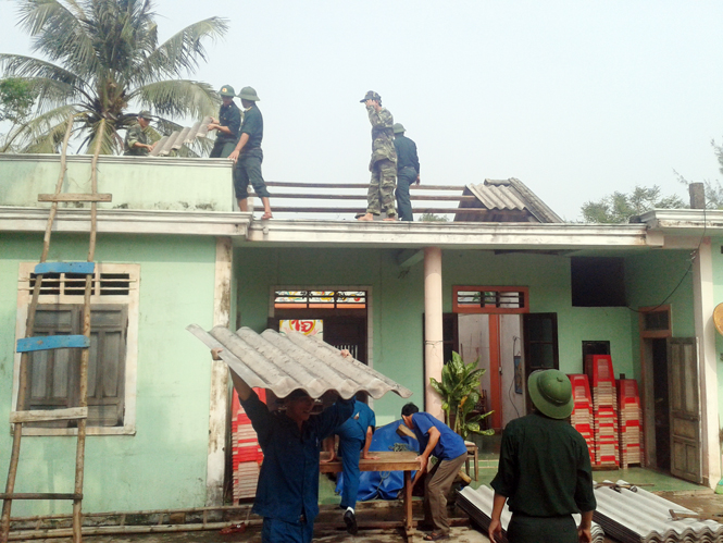 và giúp dân lợp lại nhà sau cơn bão số 10-2013.