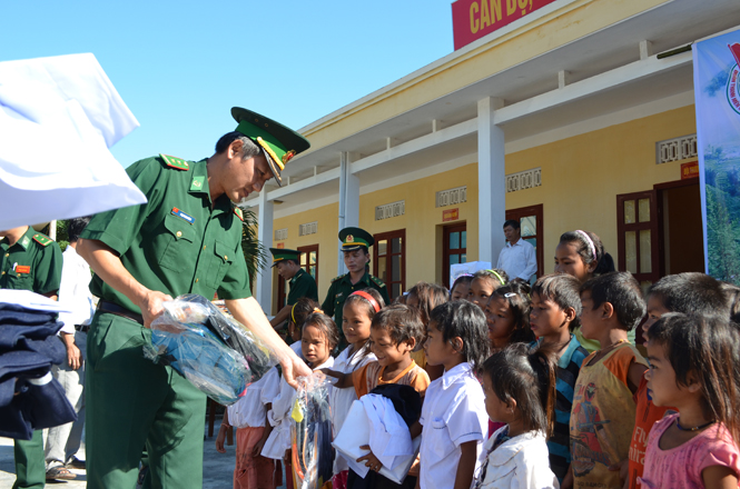 Trung tá Phạm Minh Dũng tặng quà cho các em học sinh điểm trường bản Cờ Đỏ, xã Thượng Trạch (Bố Trạch).