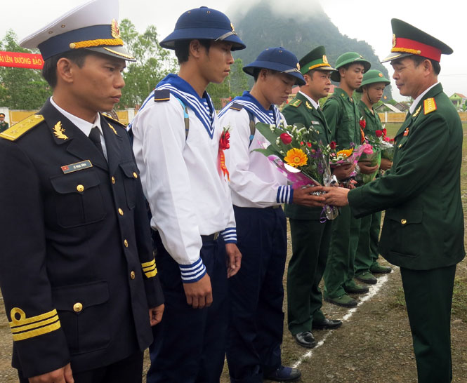 Các đồng chí lãnh đạo tỉnh tặng hoa và căn dặn, động viên tân binh huyện Minh Hóa trước lúc lên đường.