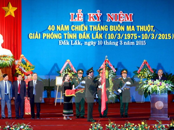 Đại tướng Trần Đại Quang gắn Huân chương Độc lập hạng Ba lên cờ truyền thống của thành phố Buôn Ma Thuột. (Ảnh: Dương Giang/TTXVN)