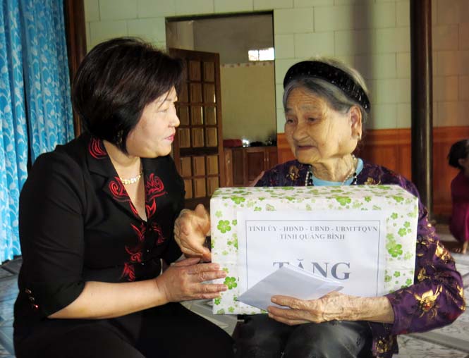 Đồng chí Nguyễn Thị Thanh Hương tặng quà bà mẹ Việt Nam anh hùng Cao Thị Khuyến ở thị trấn Quy Đạt, huyện Minh Hoá.