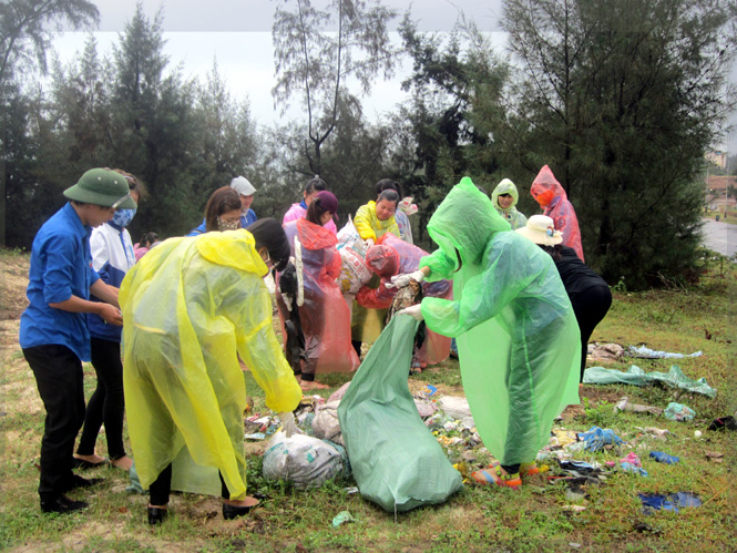 Các đoàn viên, thanh niên làm vệ sinh thu gom rác thải tại bãi biển Quang Phú.