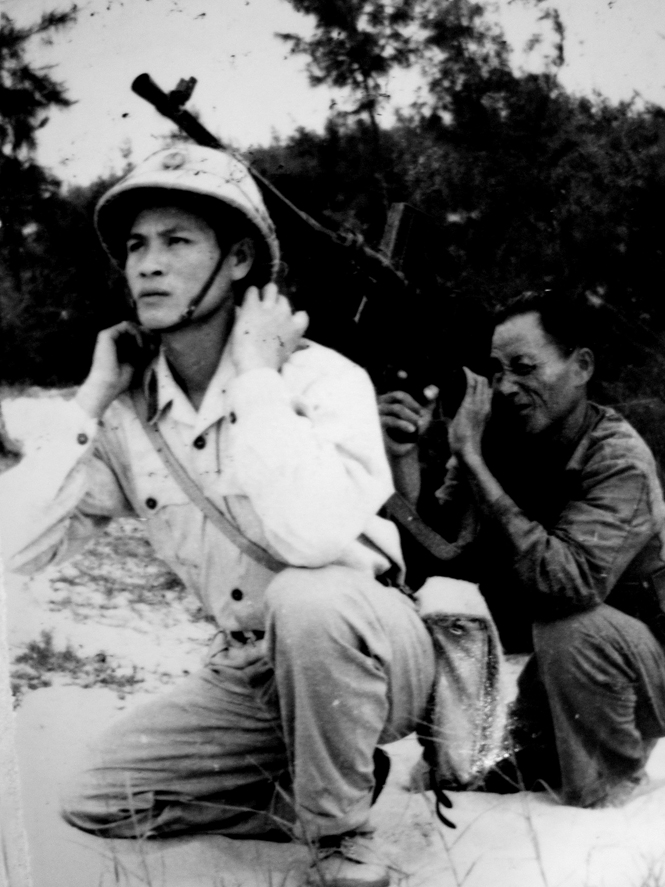 Chiến sỹ nuôi quân C356 Lương Công Lợi lấy thân mình làm giá súng cho ông Nguyễn Mẫn, dân quân xã bắn trả máy bay Mỹ, tháng 2-1965.