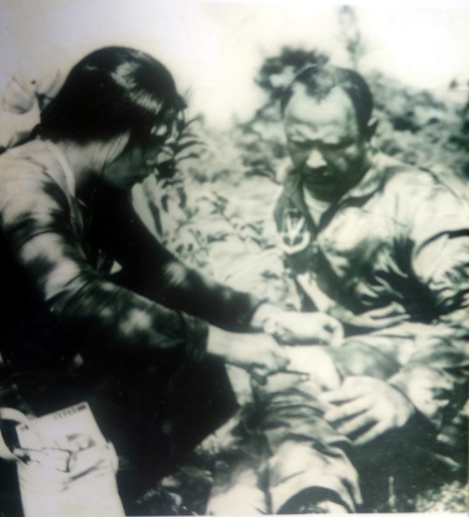 Nữ y tá Nguyễn Thị Luẫn đang băng bó vết thương cho đại úy phi công Mỹ Grap. (Ảnh do nhà báo Trọng Thanh chụp tháng 1 năm 1966).