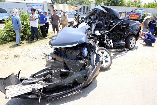 Hiện trường vụ tại nạn chiếc xe ôtô con hiệu Camry bị đâm bẹp dúm kéo lê hơn 100m. (Ảnh: Trần Lê Lâm/TTXVN)