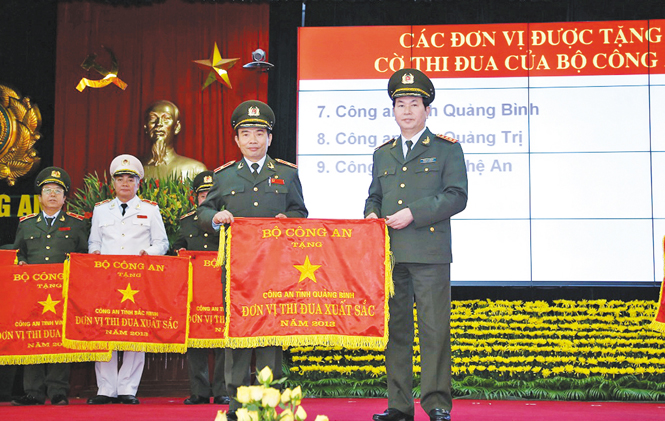 Đại tướng Trần Đại Quang, Ủy viên Bộ Chính trị, Bộ trưởng Bộ Công an trao cờ đơn vị thi đua xuất sắc năm 2013 cho Công an tỉnh Quảng Bình.