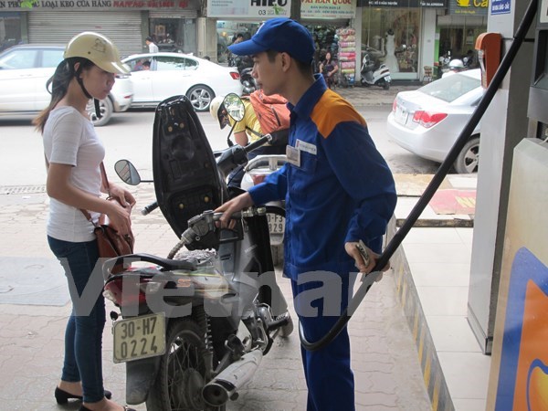 Nhân viên ​Petrolimex đang bán xăng cho khách hàng (Ảnh: Đức Duy/Vietnam+)