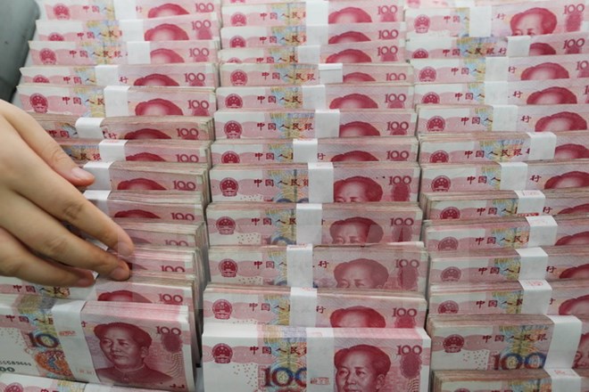 Kiểm tiền giấy mệnh giá 100 nhân dân tệ tại ngân hàng ở Liên vận cảng, tỉnh Giang tô, Trung Quốc ngày 11-8. (Nguồn: AFP/TTXVN)