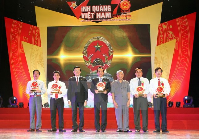 Chủ tịch nước Trương Tấn Sang tặng biểu tượng Quốc huy Việt Nam cho 5 cá nhân đại diện cho 5 vùng đất thiêng liêng của Tổ quốc tại buổi lễ. (Ảnh: Nguyễn Khang/TTXVN)