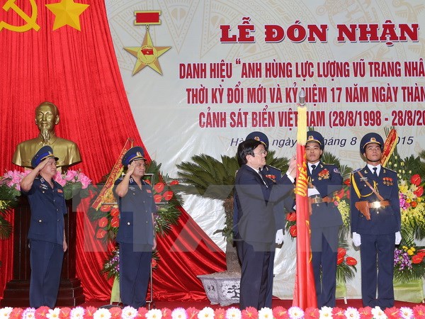 Chủ tịch nước Trương Tấn Sang gắn Danh hiệu Anh hùng lực lượng vũ trang nhân dân lên Lá cờ truyền thống của Cảnh sát biển Việt Nam. (Ảnh: Nguyễn Khang/TTXVN)