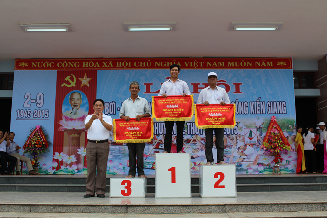 Đồng chí Nguyễn Quang Năm, Bí thư Huyện ủy, Chủ tịch UBND huyện trao giải Nhất, Nhì, Ba toàn đoàn cho các đội đua, bơi Lộc An, An Xá và Lộc Thượng.