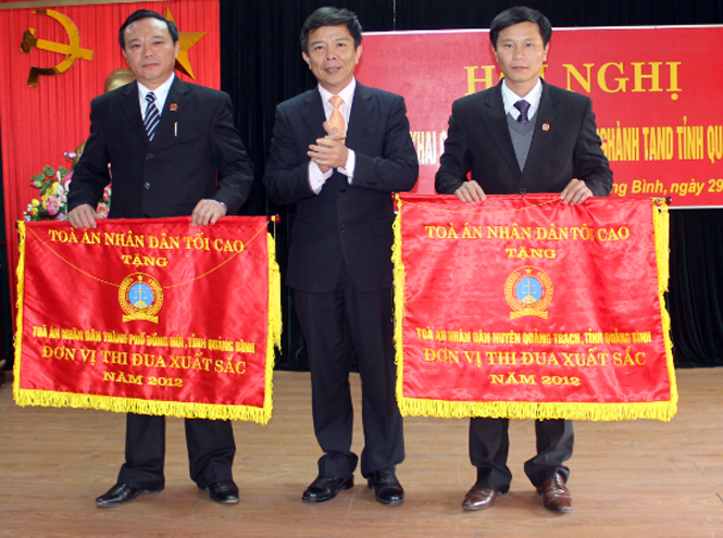Đồng chí Nguyễn Hữu Hoài, Phó Bí thư Tỉnh ủy, Chủ tịch UBND tỉnh, trao cờ thi đua của TAND Tối cao cho TAND TP.Đồng Hới và TAND huyện Quảng Trạch năm 2012.