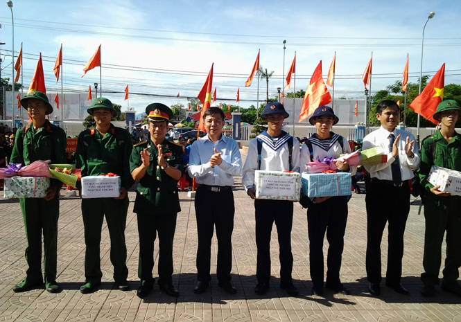    Đồng chí Nguyễn Hữu Hoài, Phó Bí thư Tỉnh uỷ, Chủ tịch UBND tỉnh và đại diện lãnh đạo thị xã Ba Đồn tặng hoa và quà cho các tân binh