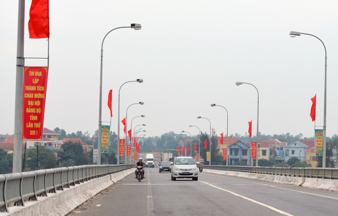 Hai bên cầu Quán Hàu rực rỡ cờ và biểu ngữ chào mừng Đại hội Đảng bộ tỉnh lần thứ XVI