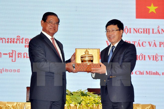 Phó Thủ tướng, Bộ trưởng Bộ Ngoại giao Việt Nam Phạm Bình Minh và Phó Thủ tướng, Bộ trưởng Bộ Nội vụ Campuchia Samdech Krolahom Sar Kheng trao tặng quà lưu niệm. (Ảnh: Thanh Vũ/TTXVN)