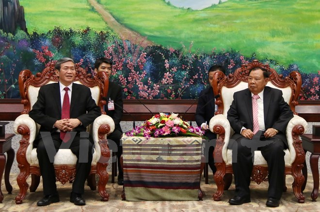 Tổng Bí thư Lào Bounnhang Volachith đang tiếp thân mật ông Đinh Thế Huynh. (Ảnh: Phạm Kiên/Vietnam+)