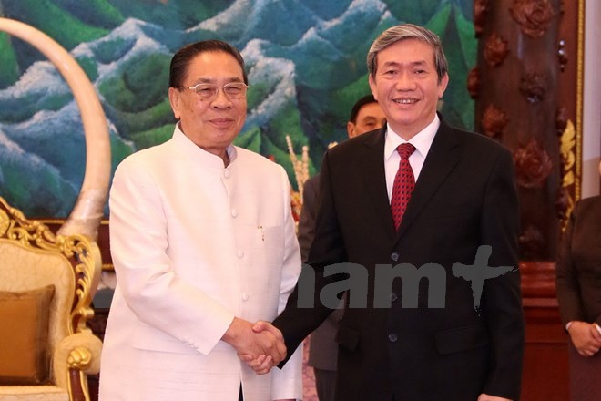 Chủ tịch nước Chummaly Sayasone đang chào đón ông Đinh Thế Huynh. (Ảnh: Phạm Kiên/Vietnam+)