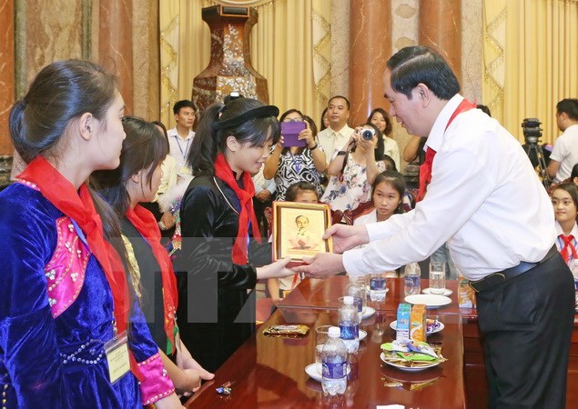 Chủ tịch nước Trần Đại Quang tặng chân dung Chủ tịch Hồ Chí Minh cho các các thiếu nhi. (Ảnh: Nhan Sáng/TTXVN)