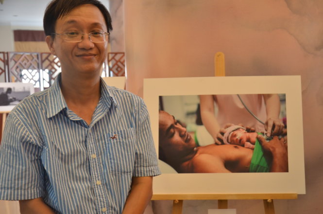 Tác giả Huỳnh Nam Đông và tác phẩm đoạt giải nhất về người cha đang thay thế người mẹ chăm sóc con sinh non - Ảnh: MỸ PHƯỢNG