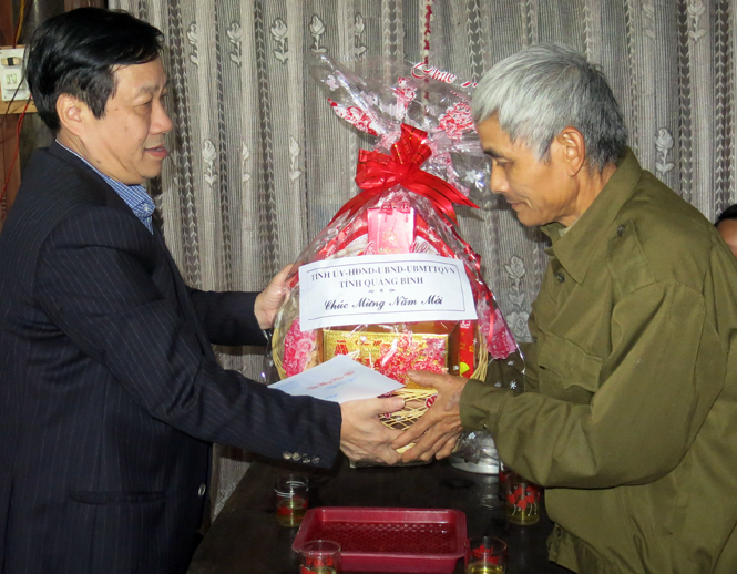 Đồng chí Nguyễn Xuân Quang, Ủy viên Ban Thường vụ Tỉnh ủy, Phó Chủ tịch Thường trực UBND tỉnh tặng quà cho thương binh Cao Thiên Thập, ở thôn Đặng Hóa, xã Hóa Sơn.