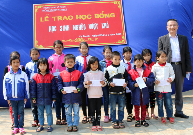 Đại diện gia đình trao học bổng cho học sinh nghèo vượt khó trong học tập tại trường Tiểu học xã Hạ Trạch.