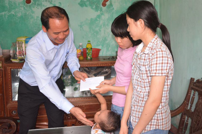  Ông Nguyễn Văn Hồi, Cục trưởng Cục Bảo trợ xã hội thuộc Bộ LĐ-TB&XH, thăm hỏi, trao quà của Thủ tướng Chính phủ cho ba chị em Sáng. Ảnh Tuổi trẻ