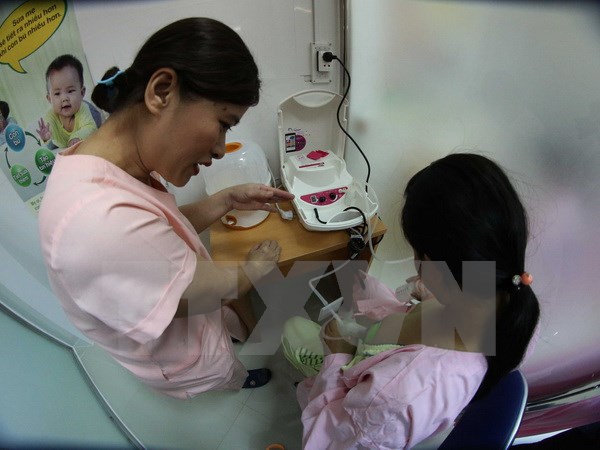  Nhân viên y tế hướng dẫn các bà mẹ đến hiến tặng sữa cách sử dụng máy hút sữa. (Ảnh: Trần Lê Lâm/TTXVN)