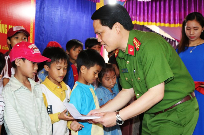 Thượng tá Bùi Quang Thanh, Trưởng Công an thị xã Ba Đồn trao tiền hỗ trợ học sinh nghèo thôn Cồn Sẻ.