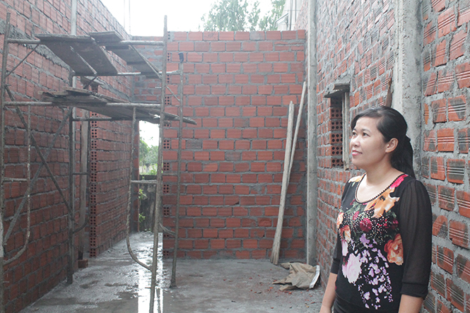 Chị Lê Thị Hương Giang, giáo viên Trường tiểu học Quang Phú, Đồng Hới vui mừng bên ngôi nhà mới đang được xây dựng.