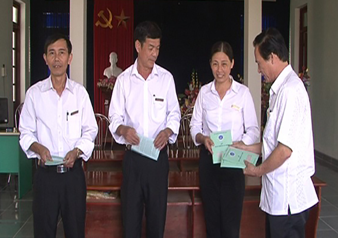 Đại diện BHXH huyện Quảng Ninh bàn giao sổ BHXH cho người lao động.