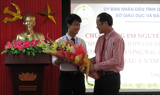 Đồng chí Trần Công Thuật, Phó Bí thư Thường trực Tỉnh ủy tặng hoa chúc mừng em Nguyễn Thế Quỳnh đoạt huy chương Bạc kỳ thi Olympic Vật lý Châu Á năm 2017.