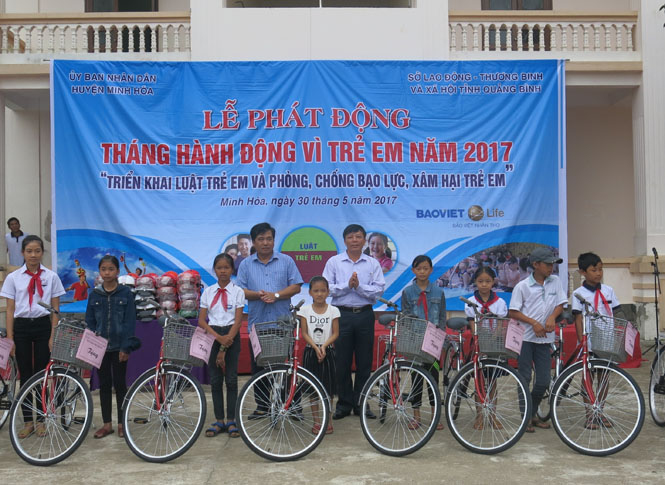 Lãnh đạo Sở Lao động - Thương binh và Xã hội cùng lãnh đạo huyện Minh Hóa trao xe đạp cho học sinh có hoàn cảnh đặc biệt khó khăn