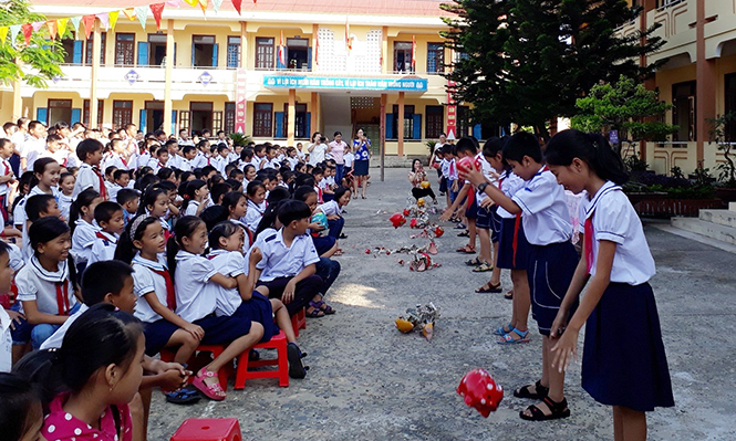 Các em học sinh Trường tiểu học số 1 Võ Ninh đập heo đất để ủng hộ phong trào “Kế hoạch nhỏ”.