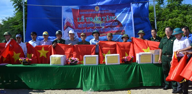 Đại diện lãnh đạo Đảng ủy, Hội CCB Khối Doanh nghiệp tỉnh trao cờ Tổ quốc cho ngư dân phường Quảng Phúc.