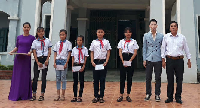 Ca sĩ Jay Hoo trao học bổng cho các em học sinh.