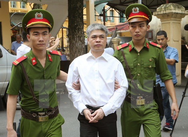 Cảnh sát dẫn giải bị cáo Nguyễn Xuân Sơn, nguyên Tổng giám đốc Oceanbank sau khi tòa tuyên án. (Ảnh: Doãn Tấn/TTXVN)