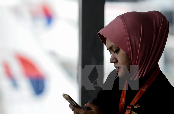 Người dân Malaysia sử dụng điện thoại di động tại Sepang. (Nguồn: AFP/TTXVN)