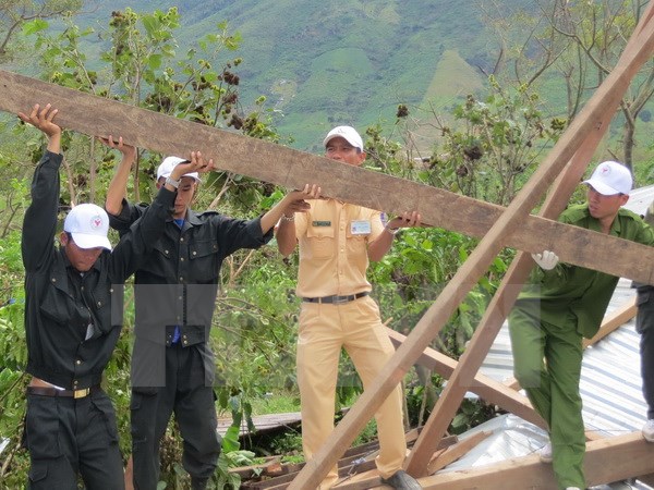 Cán bộ, chiến sỹ Công an tỉnh Đắk Lắk dựng lại nhà cho người dân huyện Krông Bông. (Ảnh: Phạm Cường/TTXVN)