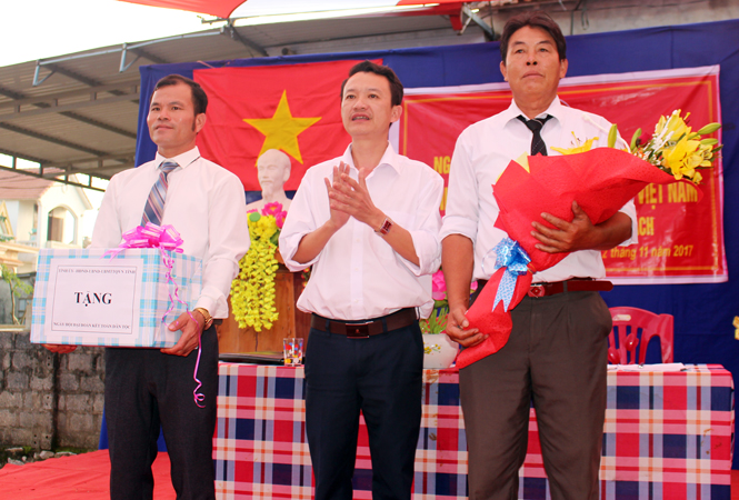 Đồng chí Trần Quang Minh, Phó Chủ tịch UBMTTQ Việt Nam tỉnh tặng quà cho đại diện lãnh đạo thôn Phú Kinh (xã Liên Trạch, huyện Bố Trạch).