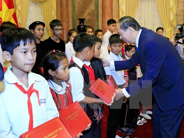  Chủ tịch nước Trần Đại Quang tặng quà cho các học sinh dân tộc thiểu số. (Ảnh: Nhan Sáng/TTXVN)
