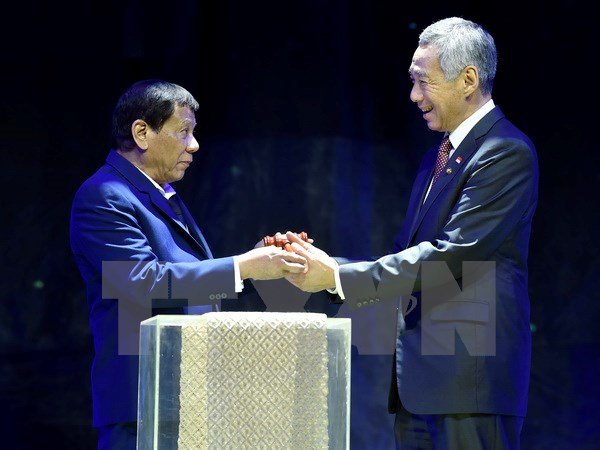 Thủ tướng Singapore Lý Hiển Long (phải) nhận biểu tượng tại lễ chuyển giao chức Chủ tịch luân phiên ASEAN từ Tổng thống Philippines Rodrigo Duterte tại Manila ngày 14-11. (Nguồn: THX/TTXVN)