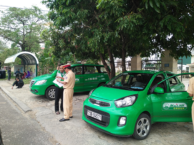  Lực lượng CSGT Công an thành phố Đồng Hới kiểm tra phương tiện taxi dừng, đỗ không đúng quy định.