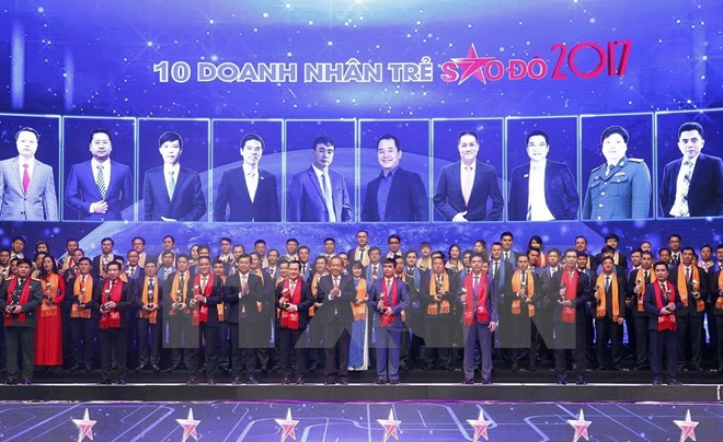 Phó Thủ tướng Thường trực Chính phủ Trương Hòa Bình cùng lãnh đạo Đảng, Nhà nước với các Doanh nhân trẻ Việt Nam tiêu biểu năm 2017 nhận giải thưởng Sao Đỏ. (Ảnh: Văn Điệp/TTXVN)